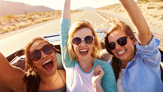 three woman enjoying time in car on road trip