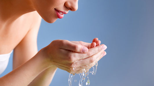 woman holding water to wash face in hand